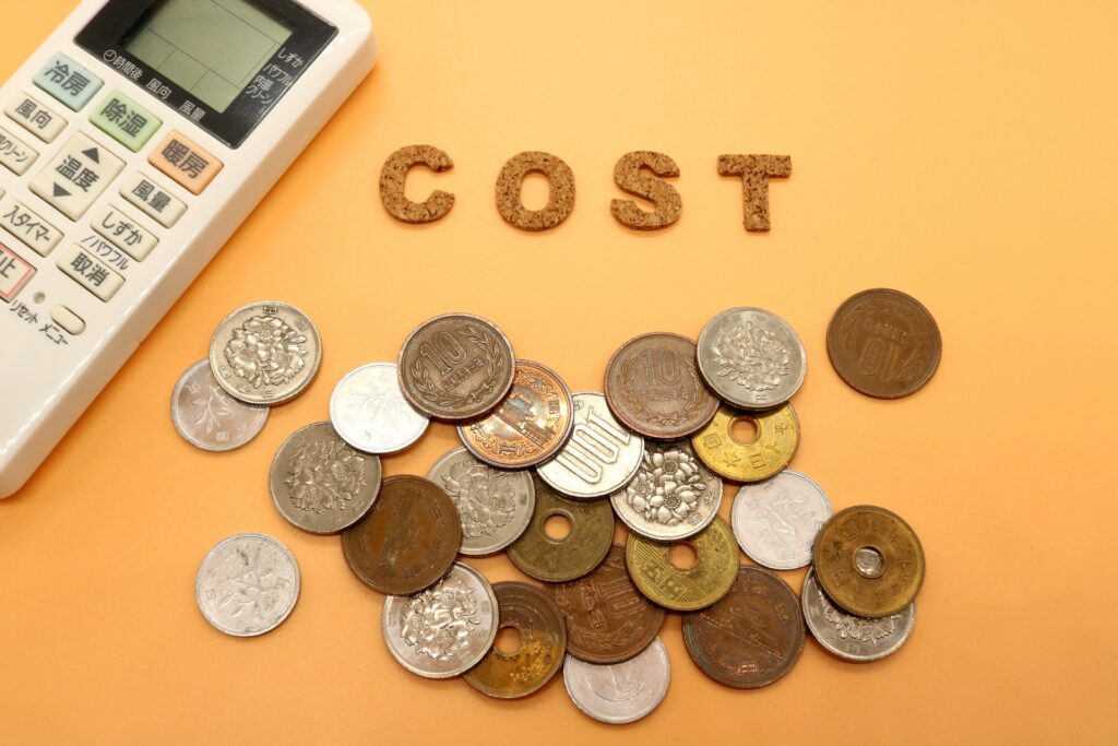 エアコンの電気代をイメージさせる小銭とリモコン