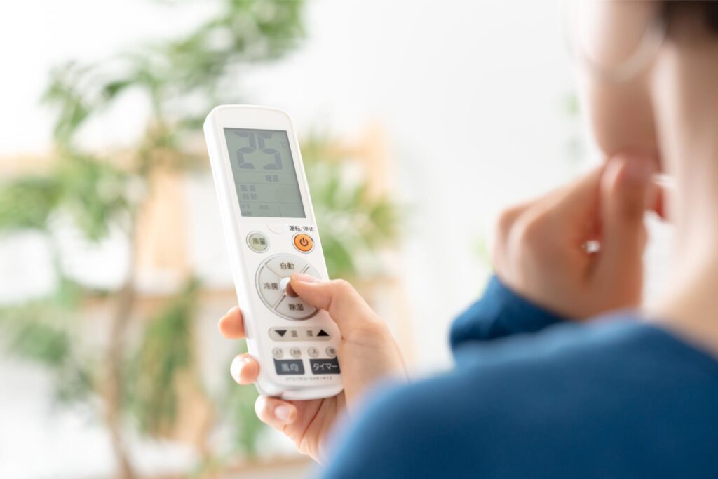 エアコンを操作する女性