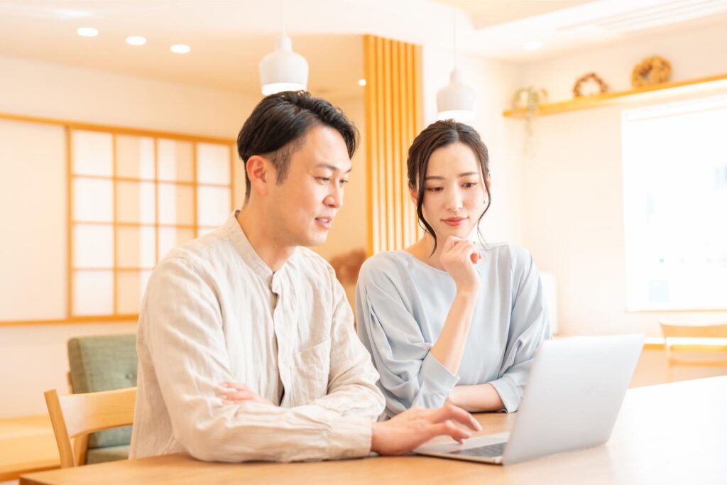 パソコンを一緒に見る夫婦