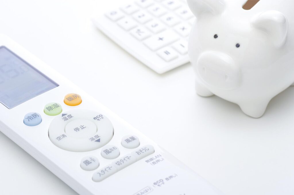 電気代節約をイメージさせる豚の貯金箱とリモコン