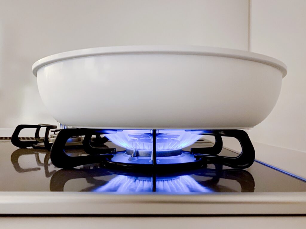 火がついたガスコンロと白い鍋