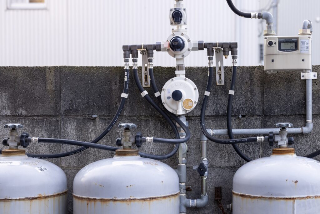 屋外のプロパンガスボンベと配管