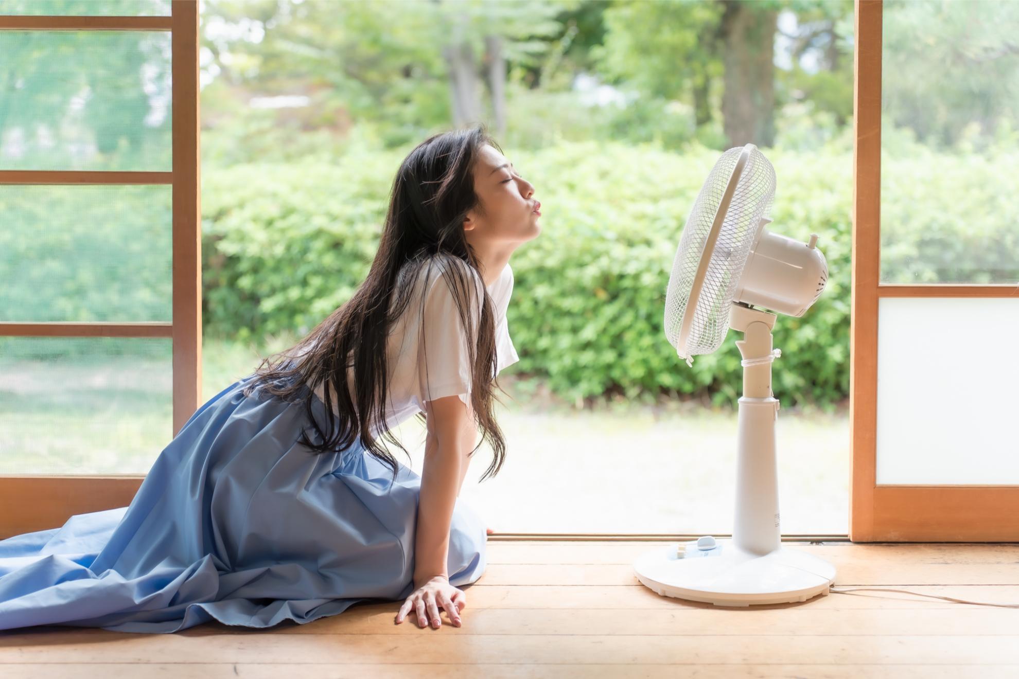 扇風機で涼む女性