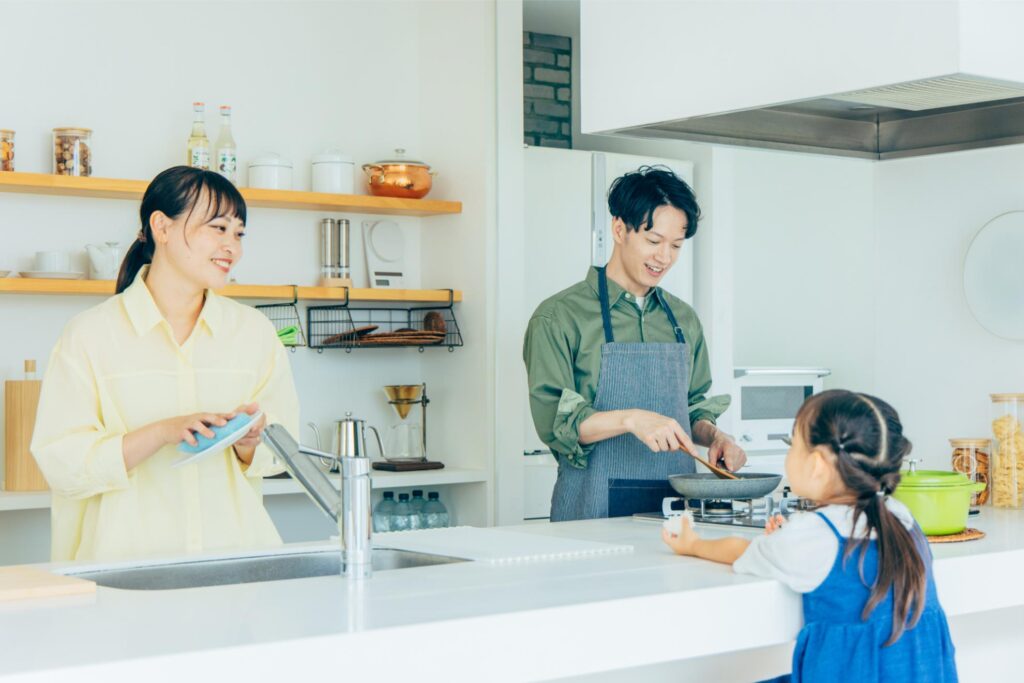 キッチンで料理をする3人家族