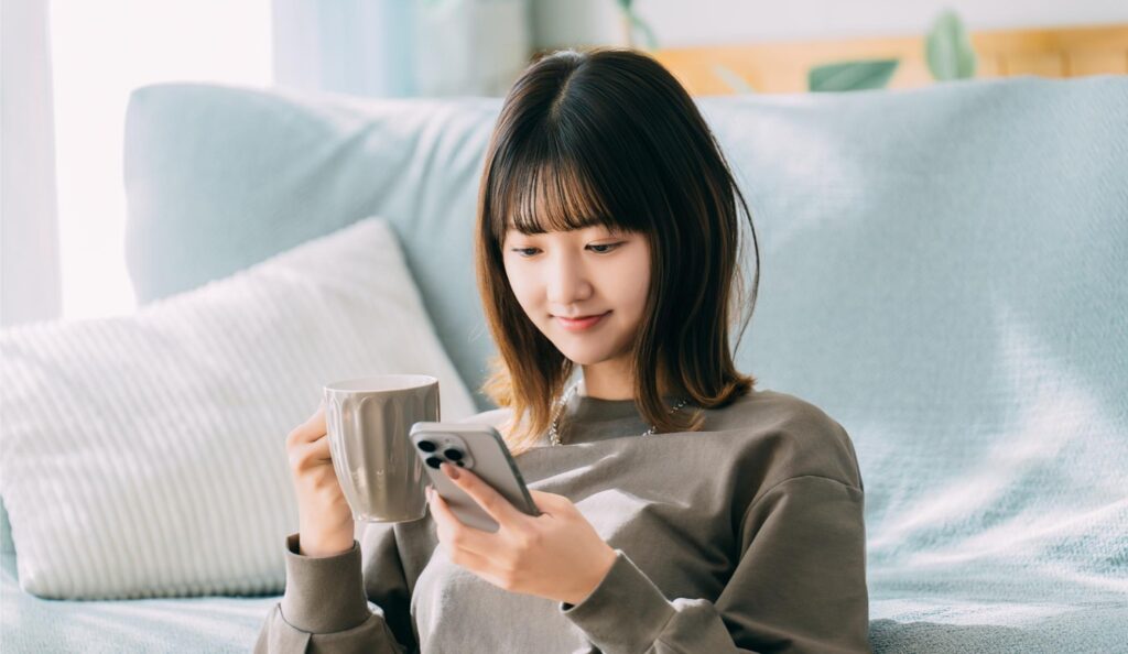 スマホを見ながらくつろぐ女性