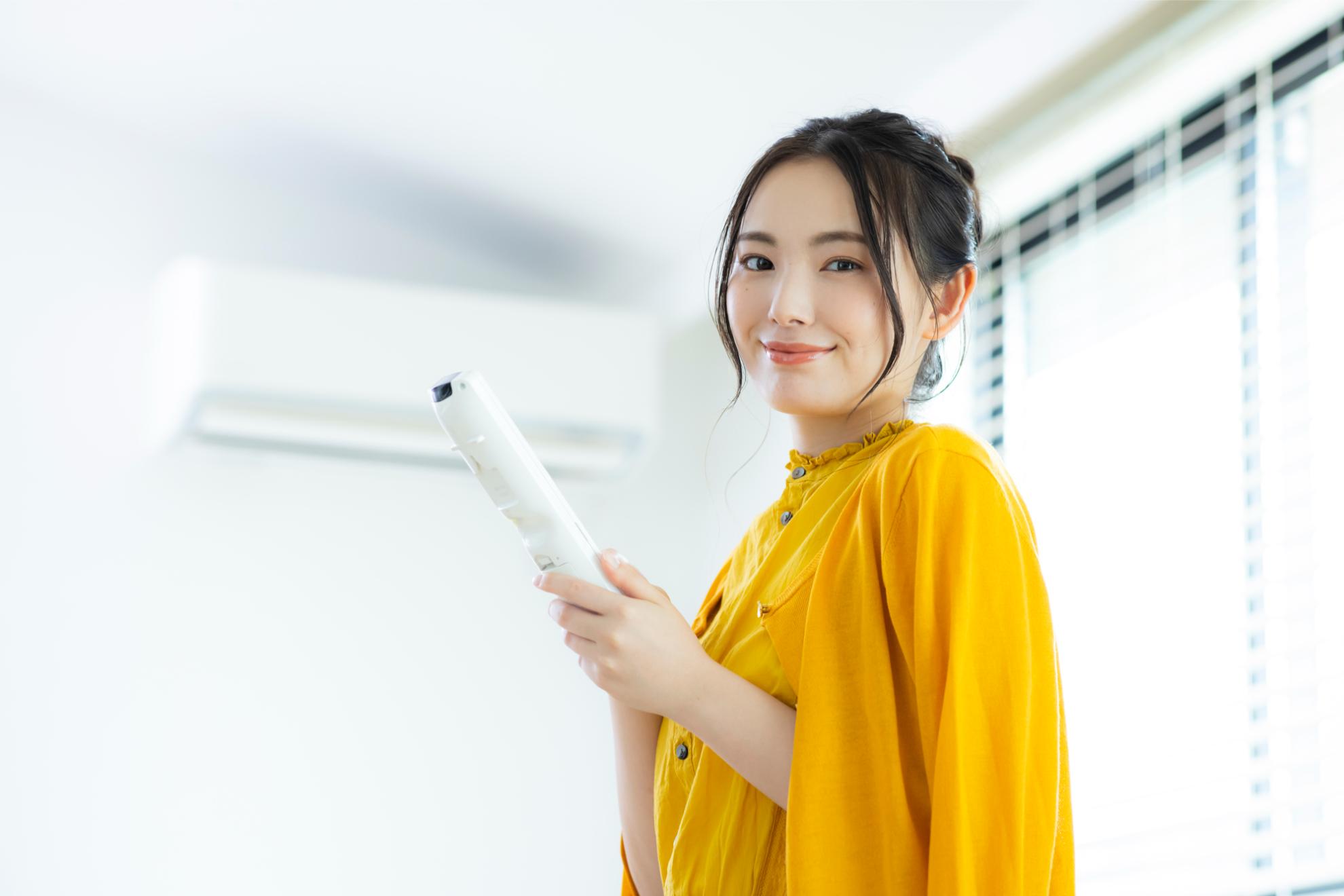 エアコンを背に笑顔の女性