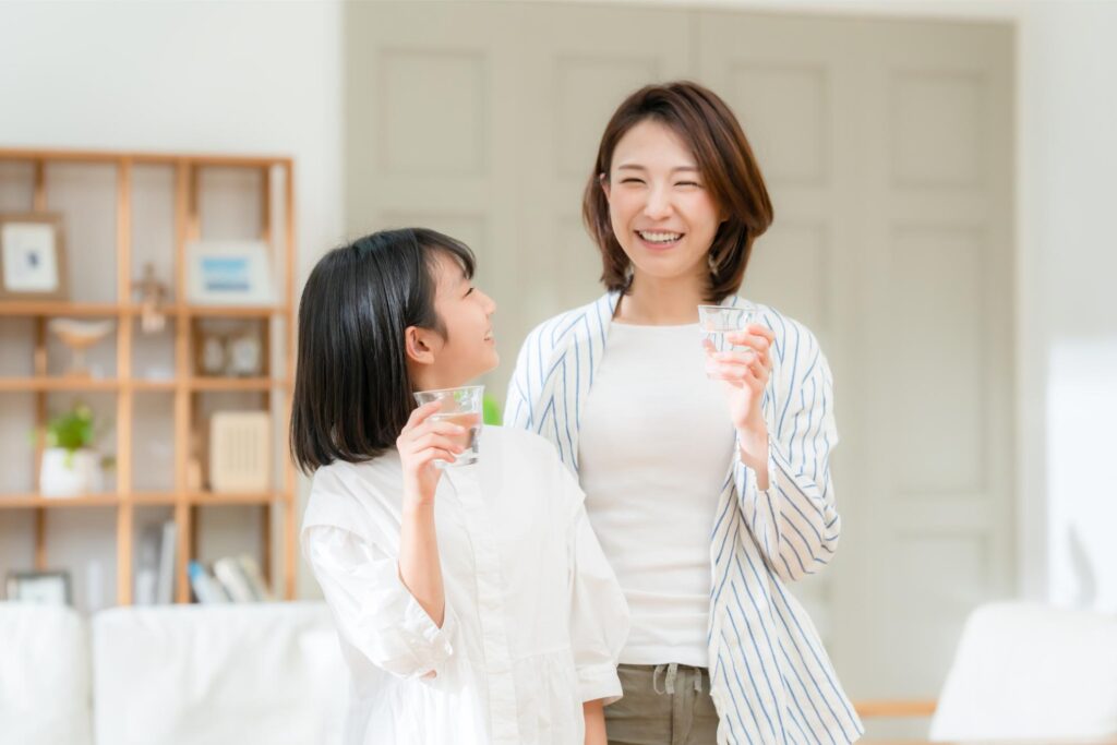 グラスを手に微笑む母と娘