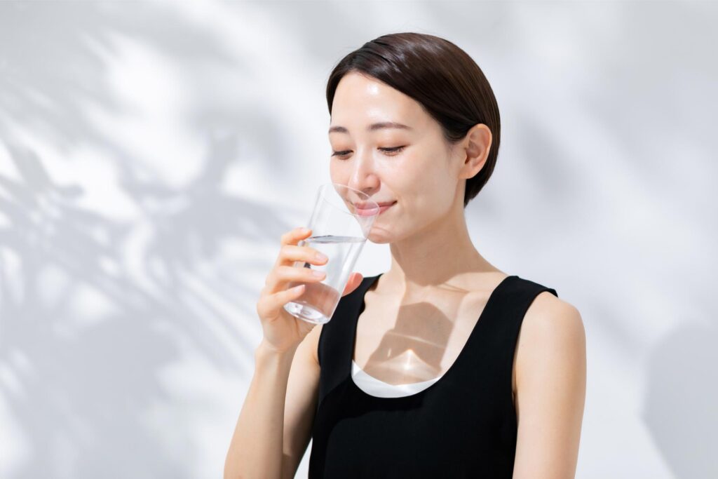グラスの水を飲む女性
