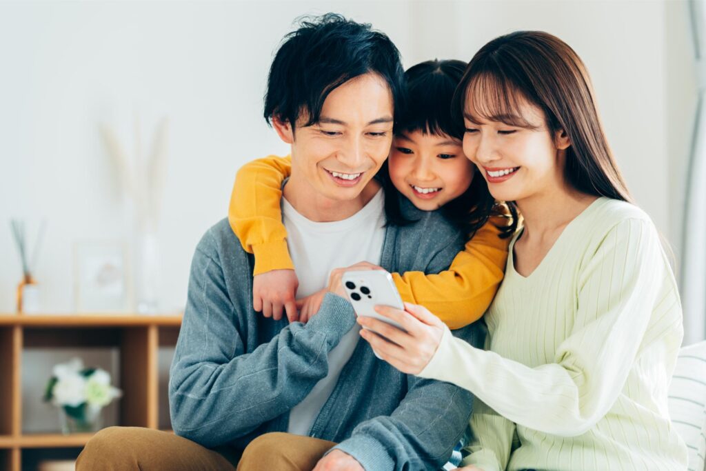 スマホを見る3人家族