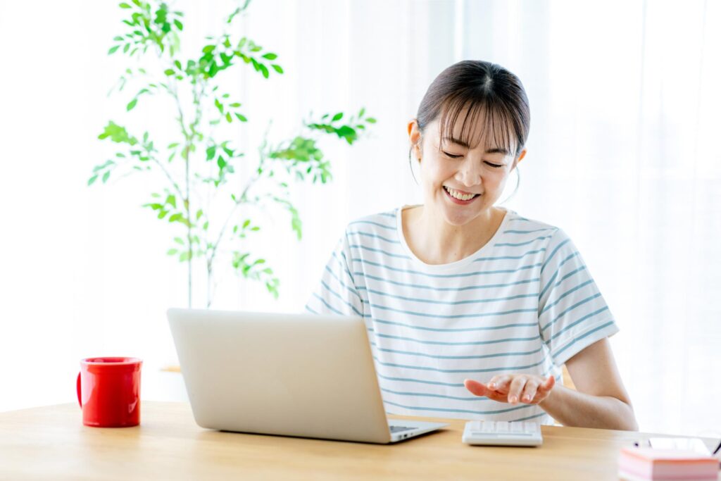 電卓とパソコンで計算する女性