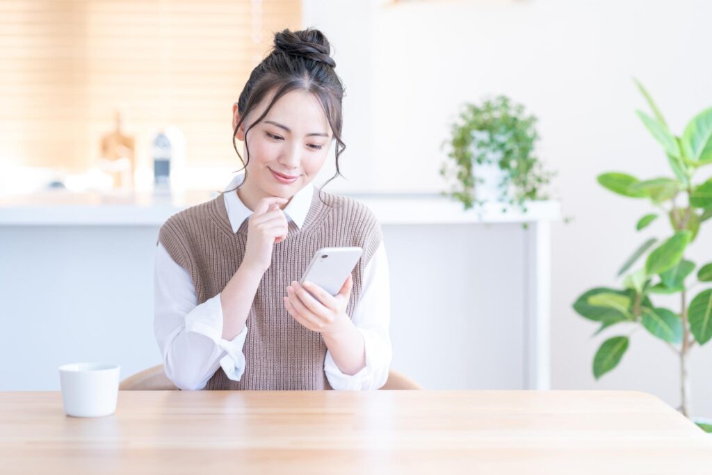 スマホを見て考える女性